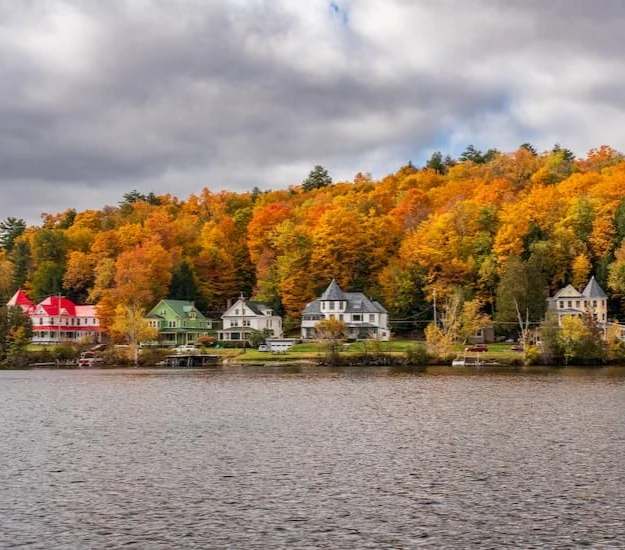 Historic hillside homes above the water in autumn in Saranac Lake, New York