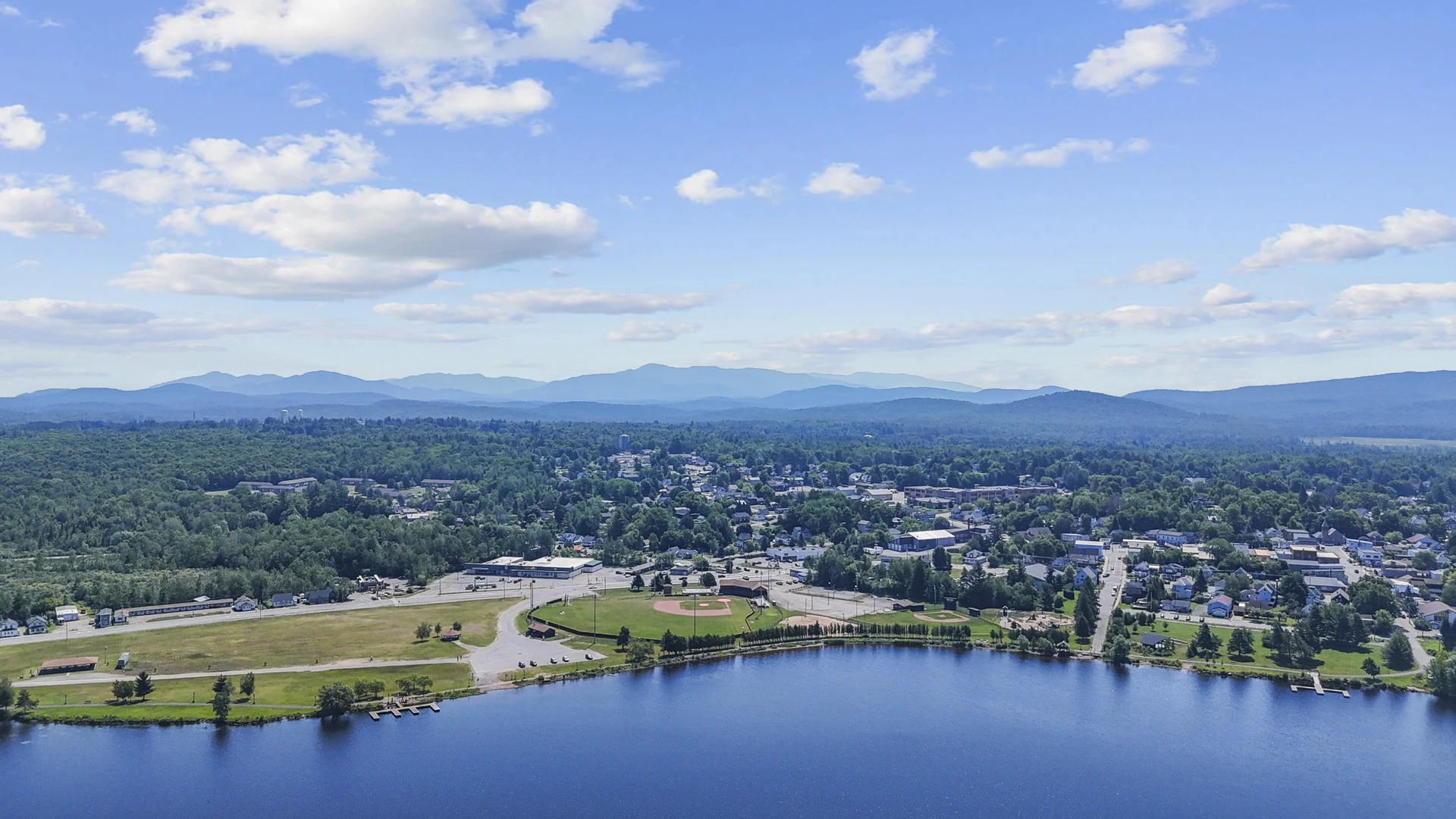 Village of Tupper Lake on the shore of Raquette Pond with Adirondack mountains in Tupper Lake, New York